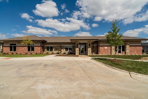 A clubhouse with a parking lot in front of it.