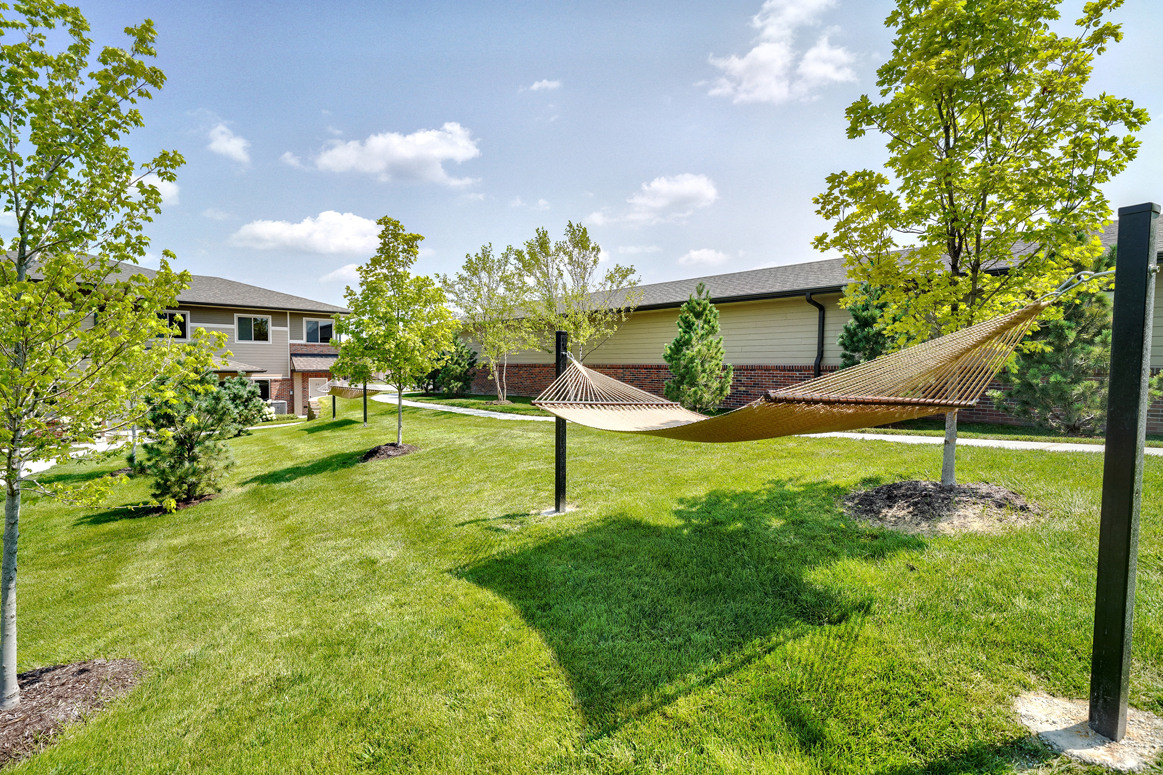 Green space near apartment building with a tan hammock