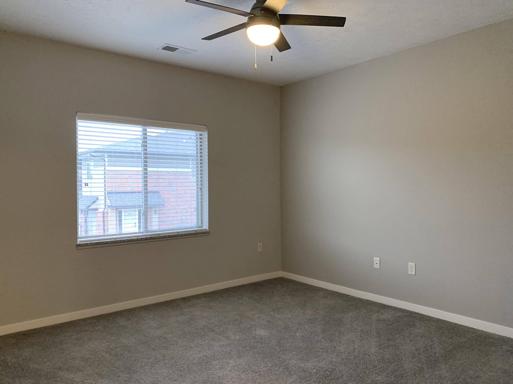 Spacious carpeted bedroom with large window allowing a lot of natural light in at The Villas at Mahoney Park