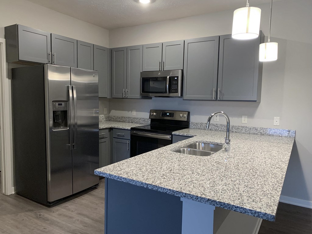 Kitchen with slate gray cabinets and matching stainless steel appliances at The Villas at Mahoney Park