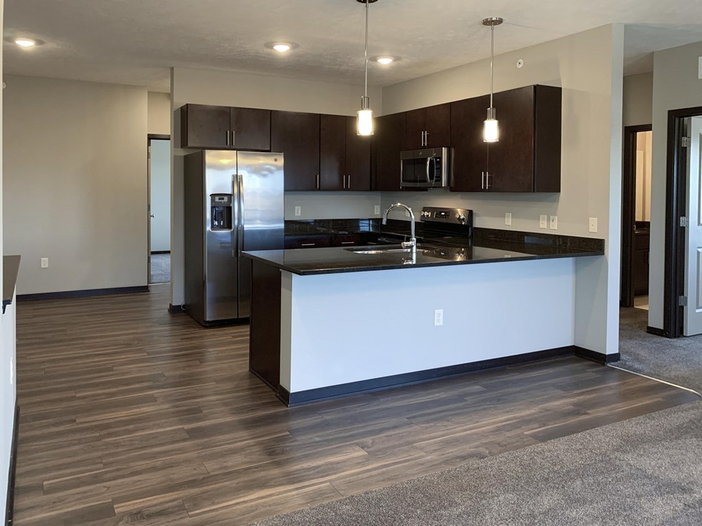 Kitchen with dark brown cabinets and matching stainless steel appliances at the villas at mahoney park