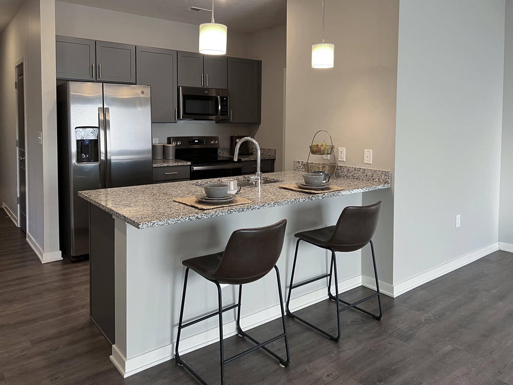 Kitchen with slate gray cabinets and matching stainless steel appliances at The Villas at Mahoney Park