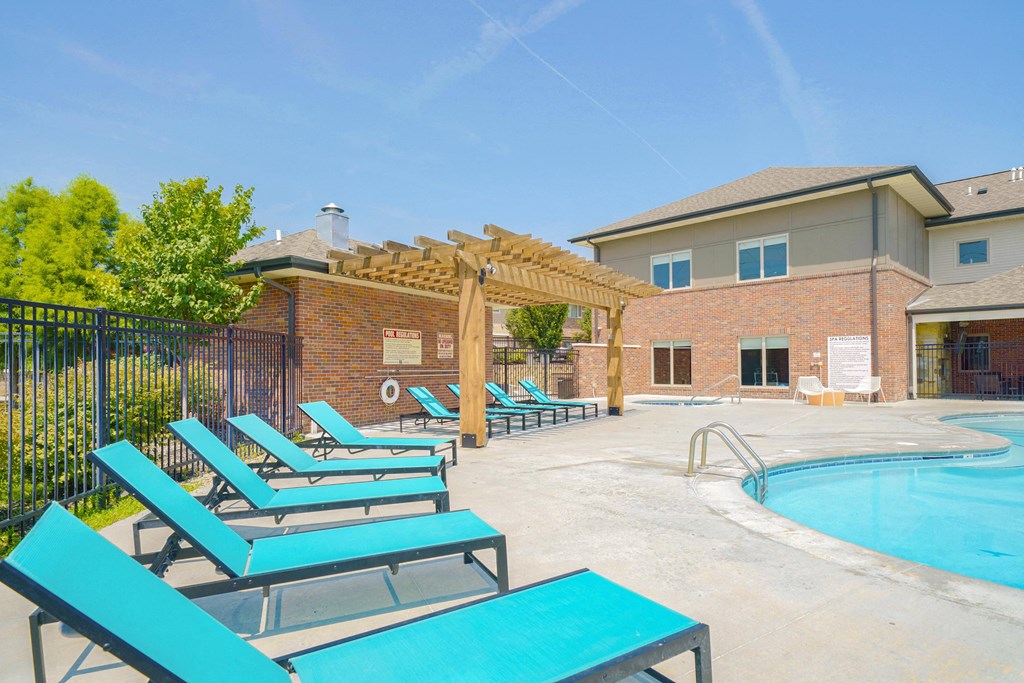 pool lounge chairs in front of a pool-side pergola