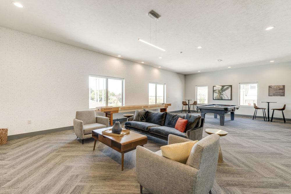 Large game room including TVs, pool tables, and shuffle board at The Villas at Mahoney Park