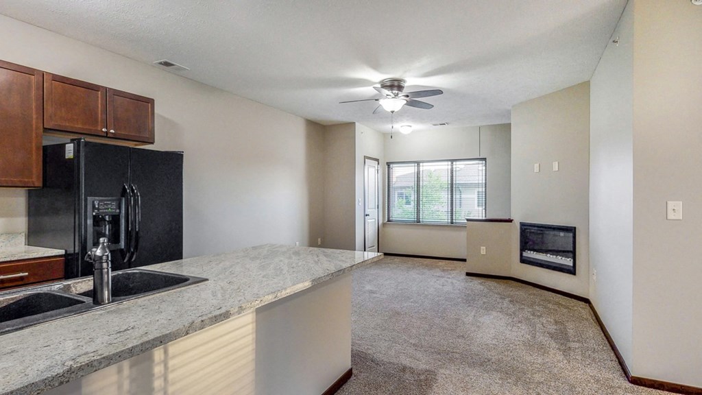 The kitchen in the Ash overlooks the living space with electric fireplace.