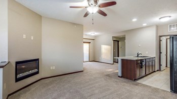 The kitchen in the Ash overlooks the living space with electric fireplace at The Villas at Wilderness Ridge luxury apartments in southwest Lincoln NE 68512 . - Photo Gallery 78