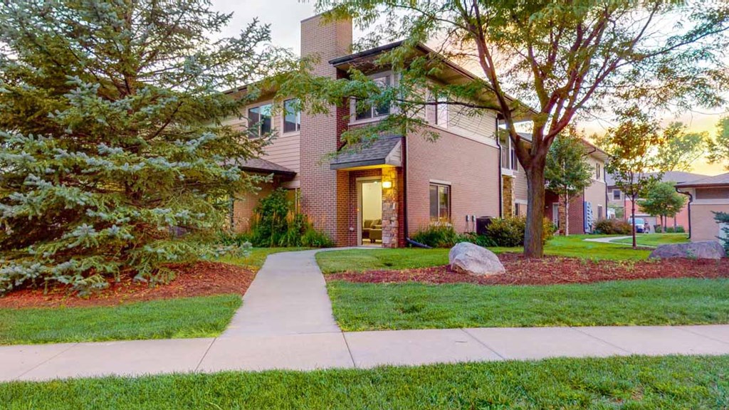 an apartment with a sidewalk in front of it