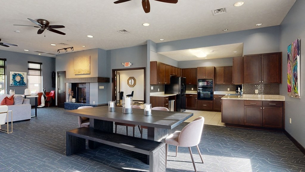 the clubhouse with a table and chairs and a kitchen in the background