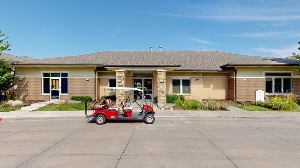 a golf cart parked in front of the clubhouse building at the villas at wilderness ridge
