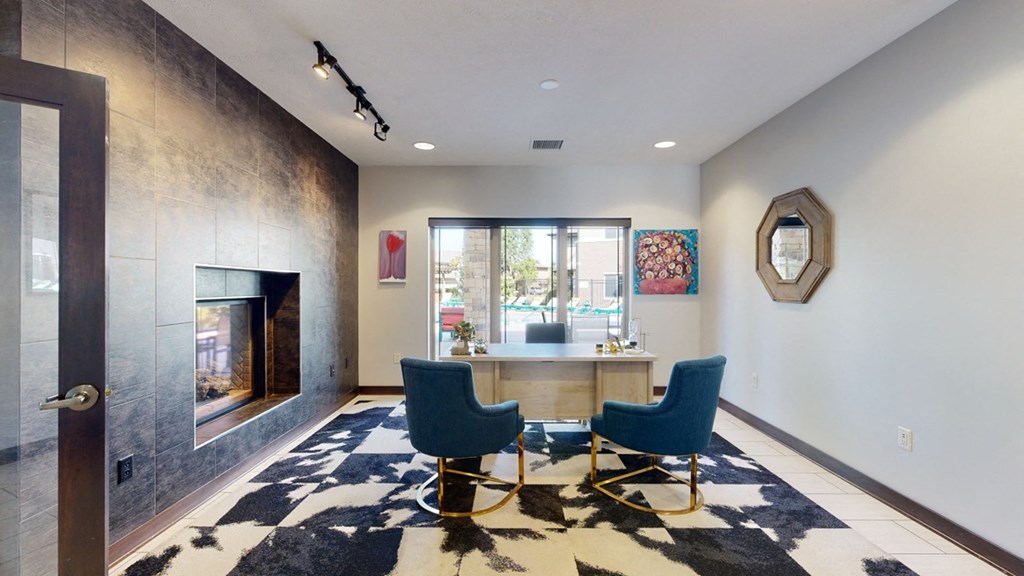 a office area with a table and chairs and a fireplace at the clubhouse