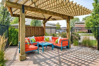 Wood pergola area with bright orange and turquoise lounge furniture positioned under it - Photo Gallery 11