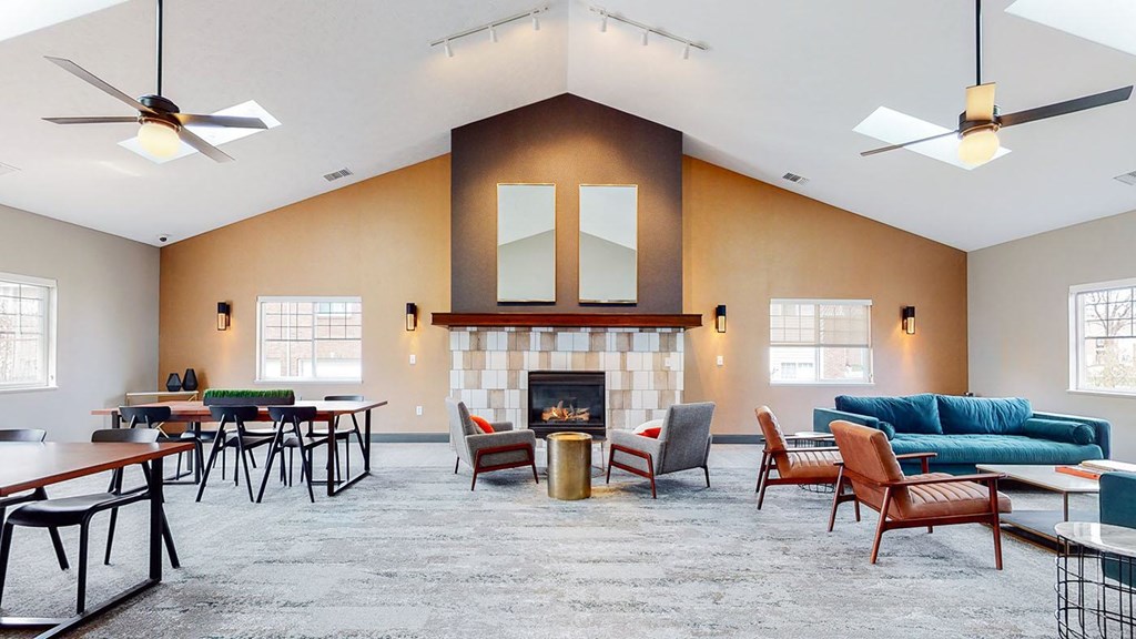 A clubhouse main room with a fireplace and multiple seating areas