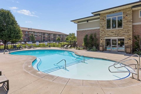 A small pool with a metal railing and a bench.