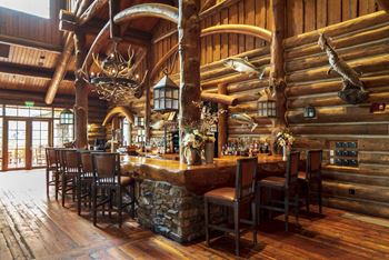 a bar inside a log cabin style restaurant