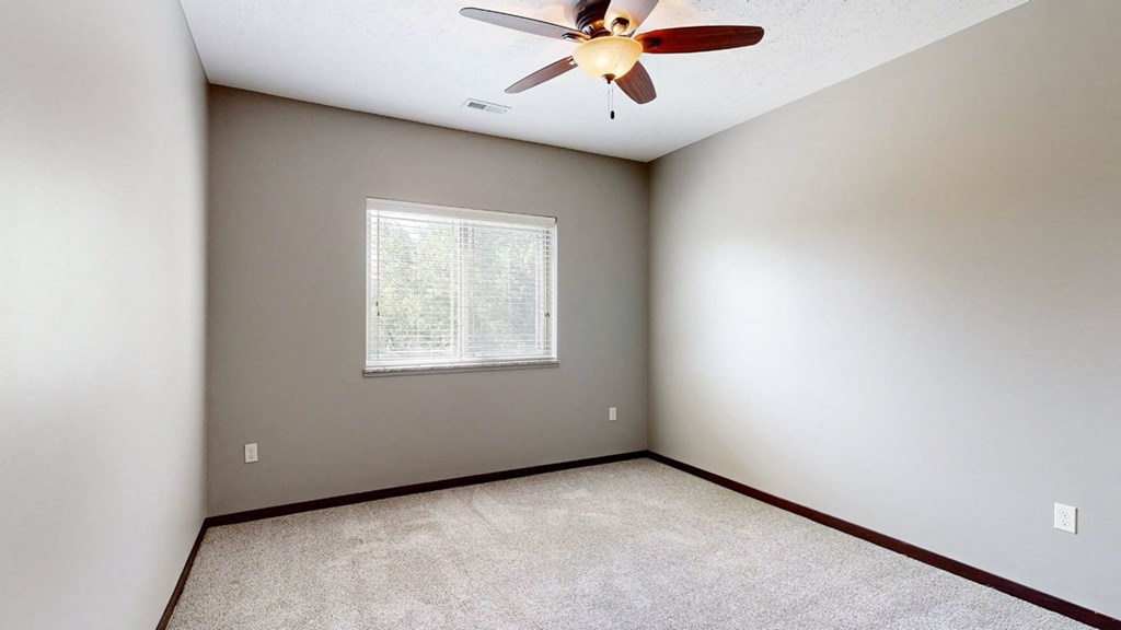 a bedroom with a ceiling fan and a window