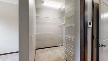 a walk-in closet in the bedroom with lots of shelves