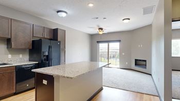 a kitchen with a light granite counter top and a black fridge