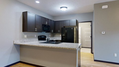 a kitchen with dark cabinets and a granite counter top