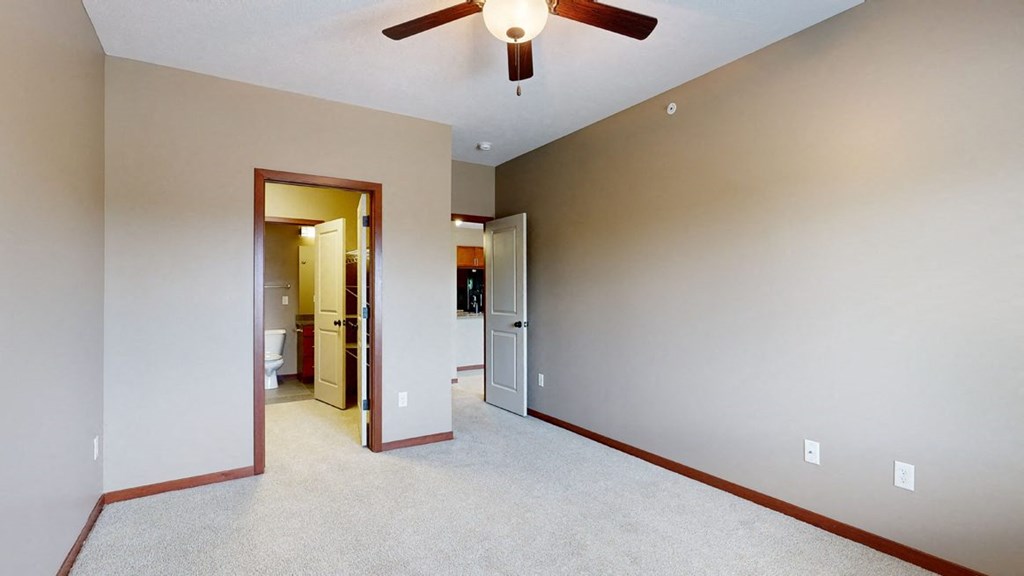 a bedroom with a walk-through closet to the bathroom