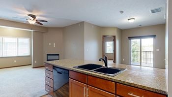 a double bowl stone sink in a kitchen and a living room and dining room adjacent