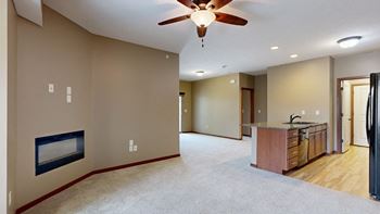 a living room with a fireplace and a ceiling fan