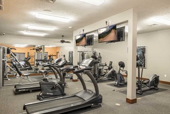 Expansive 24-hour fitness center with cardio equipment, TVs and more at Villas of Omaha townhome apartments in northwest Omaha NE 68116 - Photo Gallery 14