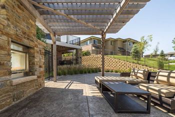 Outdoor fireplace with pergola and seating at Villas of Omaha townhome apartments in northwest Omaha NE 68116