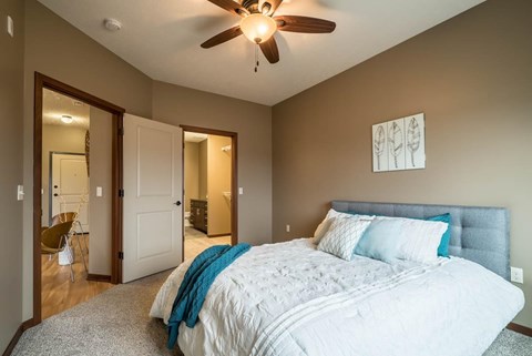 A bedroom with a large bed and a ceiling fan.