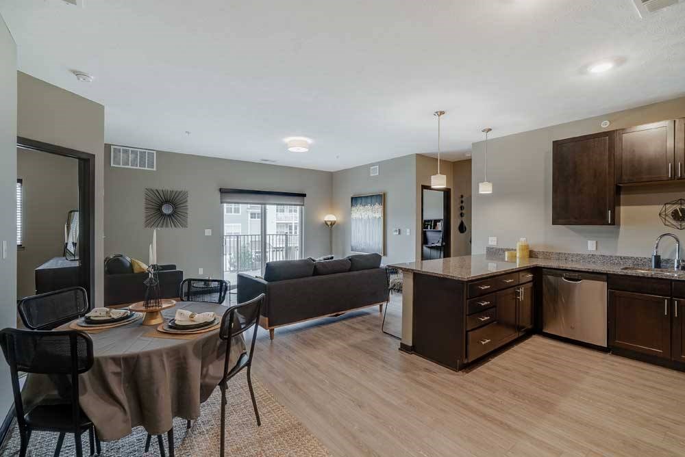 A modern kitchen with dark wood cabinets and a dining table set for two