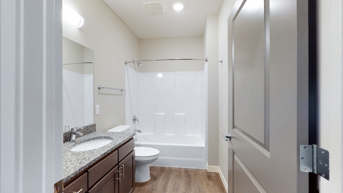 The 2 bedroom Marigold with den floor plan features a spaciou bathroom with granite vanity top and a tub/shower.
