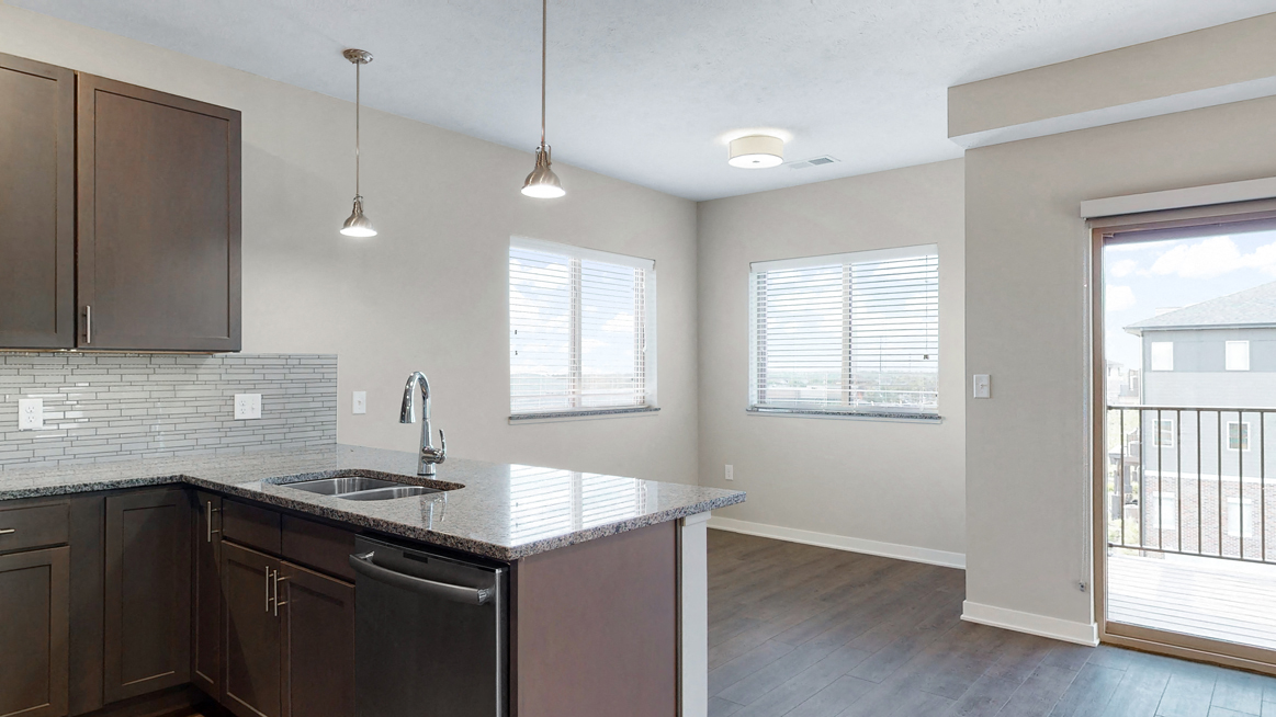 The 2 bedroom Marigold with den floor plan at WH Flats features an open eat-in kitchen area with granite countertops and large peninsula.