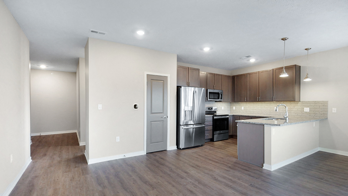 The 2 bedroom Marigold with den floor plan at WH Flats features an stainless steel appliances, granite countertops and large peninsula.