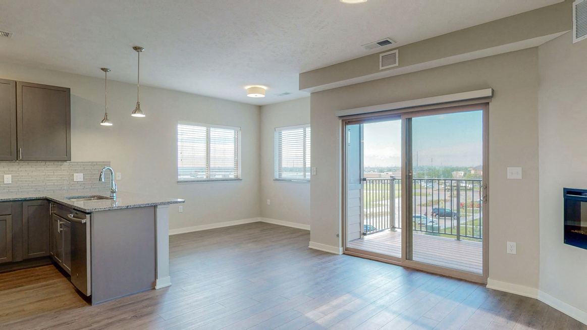 The 2 bedroom Marigold with den floor plan at WH Flats features natural light and a spacious dining and living area with electric fireplace.