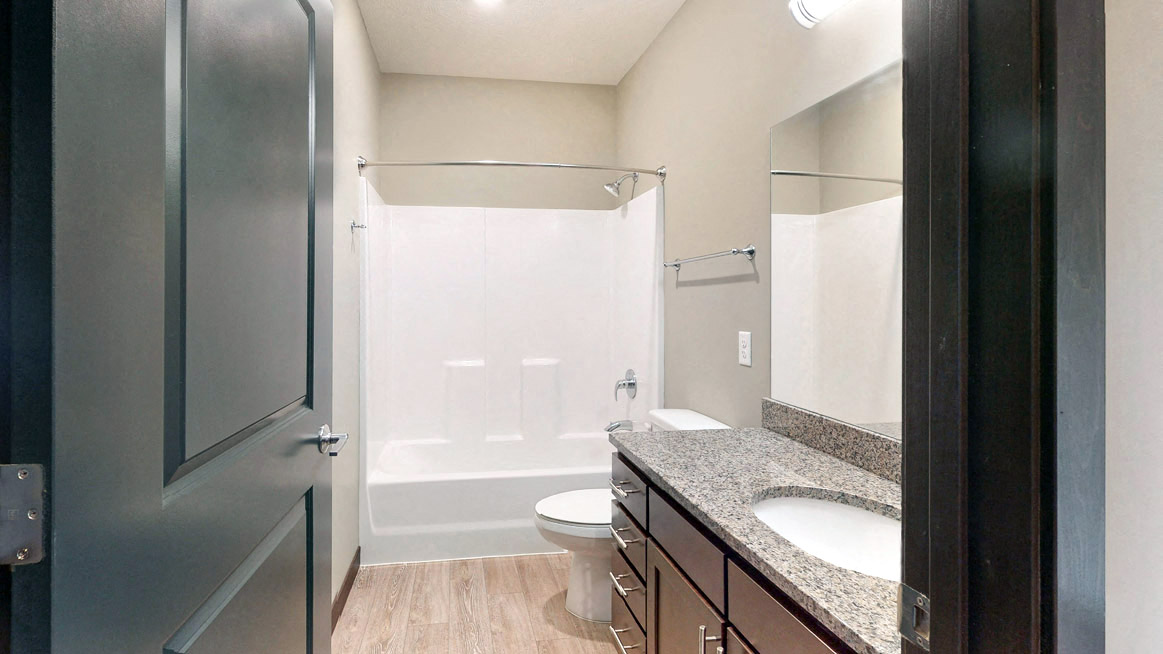 The 2 bedroom Snowdrop with den floor plan features a spacious bathroom with granite vanity top and a tub/shower.