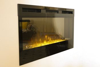 a glass fireplace with a yellow fire inside of it