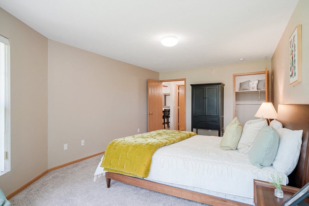 Furnished bedroom with a bed and a yellow blanket