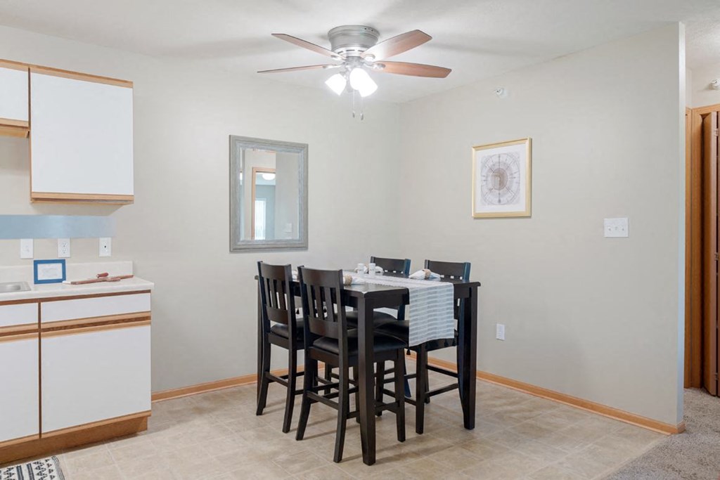 a dining room with a table and chairs and a ceiling fan