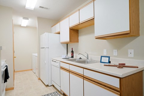 a kitchen with white cabinets and a sink and a refrigerator