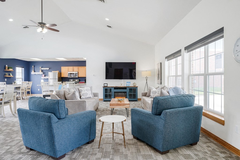 Lounging area with TV on the wall and couches and chairs