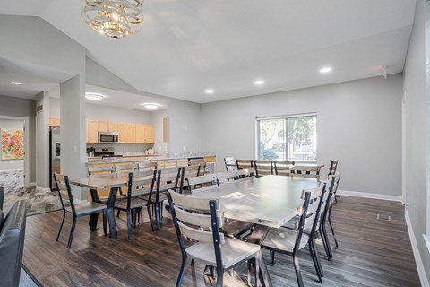 a clubhouse dining room with several tables next to a kitchen