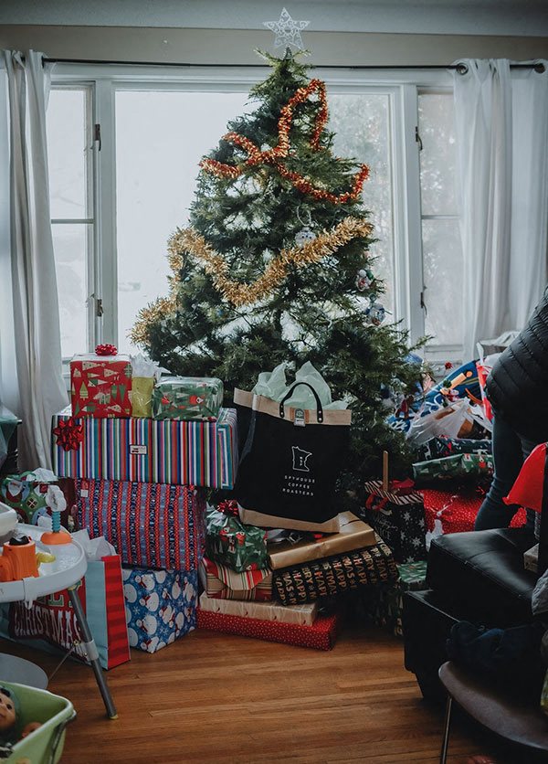 A family's decorated Christmas tree surrounded by wrapped packages and ...