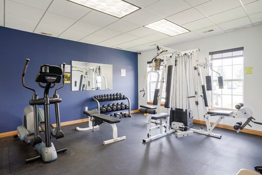 24-hour fitness center with an elliptical, dumbbell weights, and cable machine