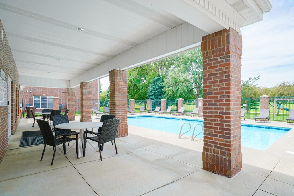 Poolside shaded patio with table and chairs