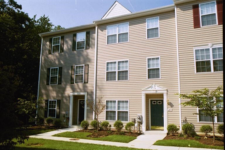 a building with two doors and a yard in front of it