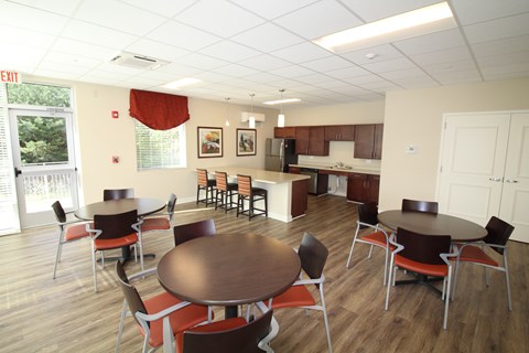 A dining room with a table surrounded by chairs.