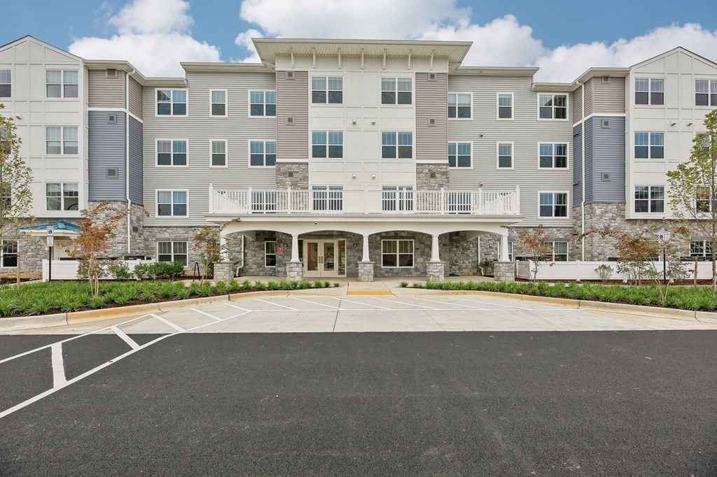 A large building with a parking lot in front.
