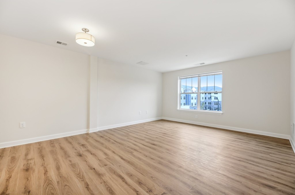 Empty room with wooden floor and a window.