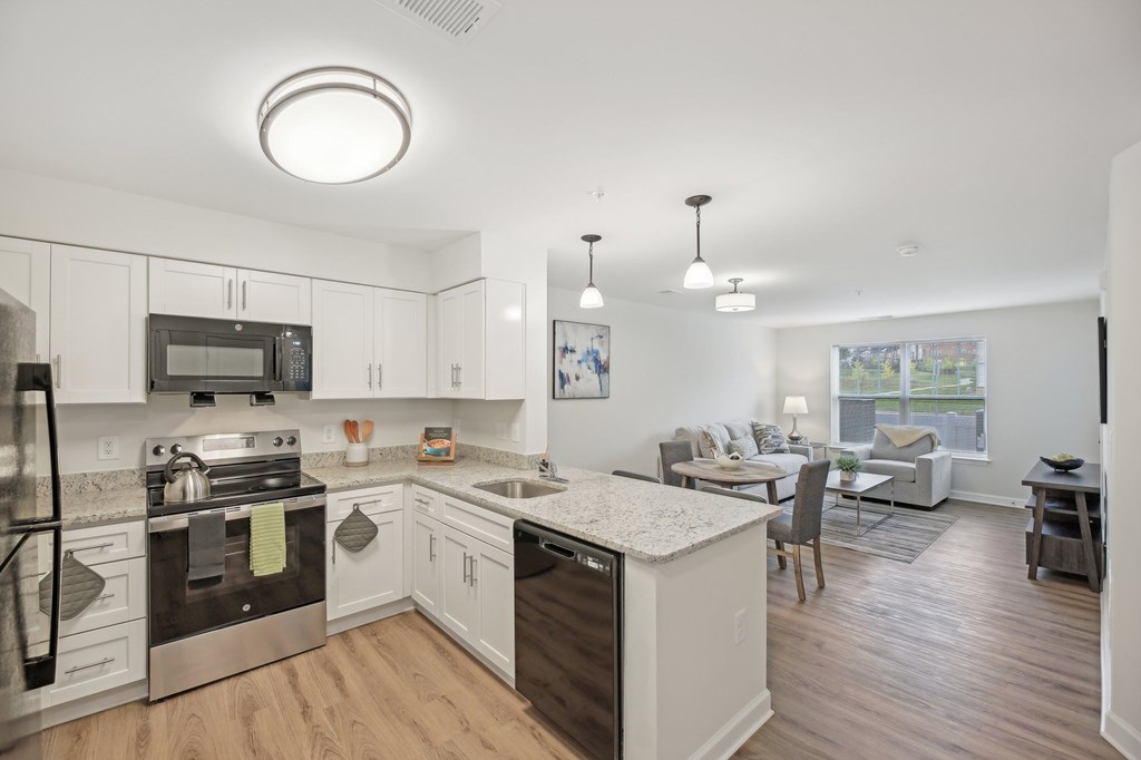 A modern kitchen with white cabinets and stainless steel appliances.