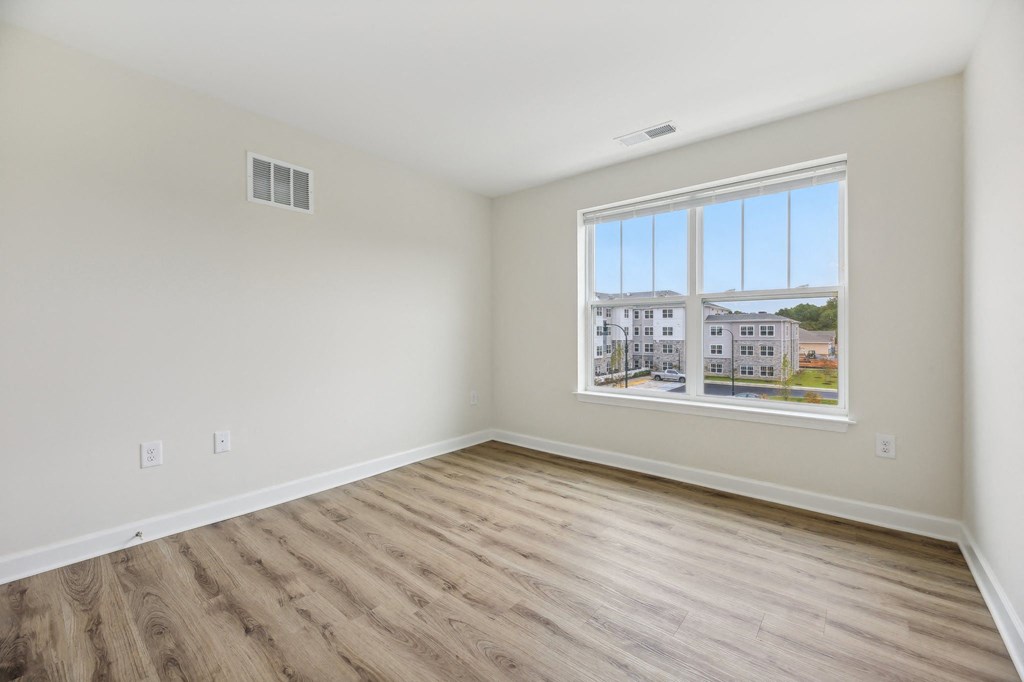 A room with a window showing a view of a building outside.