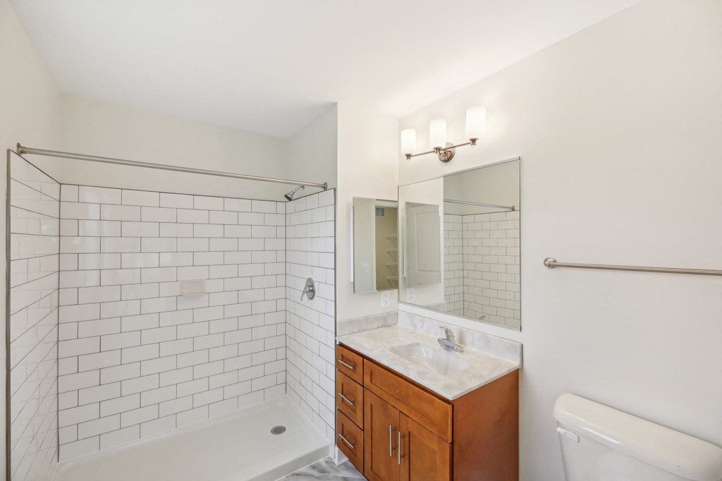 A white bathroom with a white tub and a white sink.